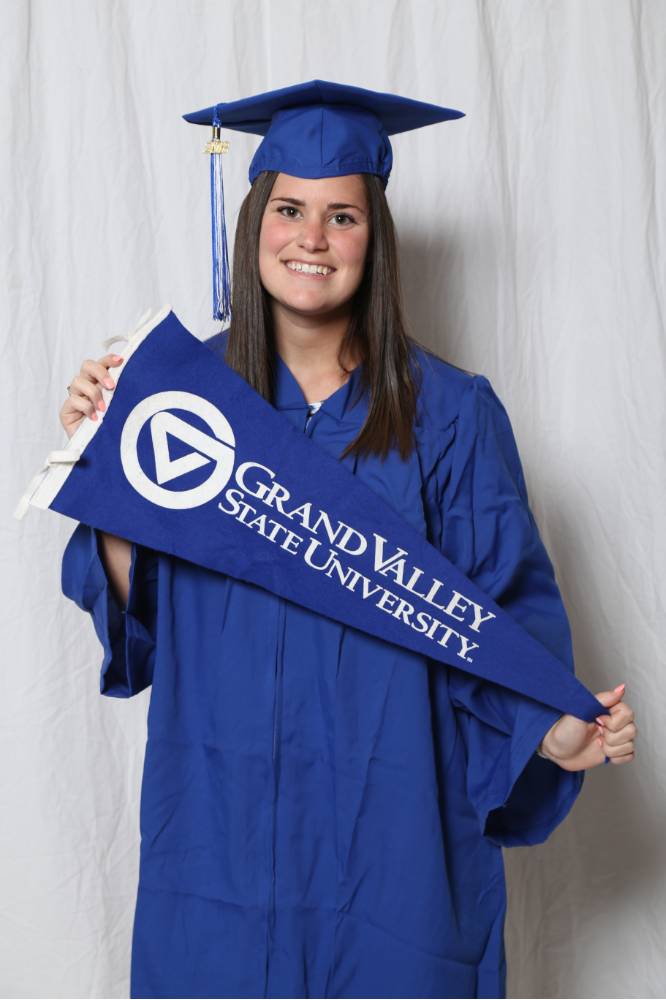 Upcoming graduate poses with GV flag